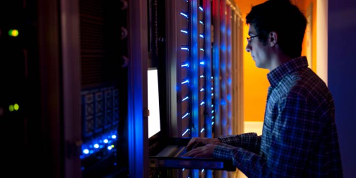 An IT engineer configures a bank of servers.