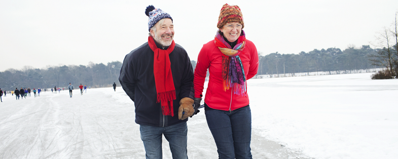 Retired couple ice skating on lake